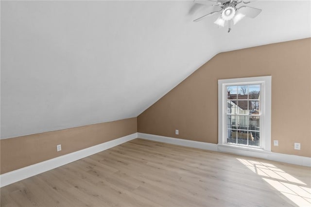 bonus room featuring lofted ceiling, a ceiling fan, light wood-type flooring, and baseboards