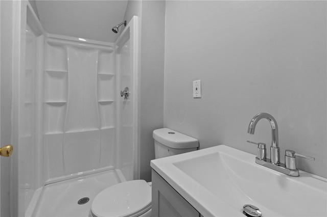 full bathroom featuring a stall shower, toilet, and vanity