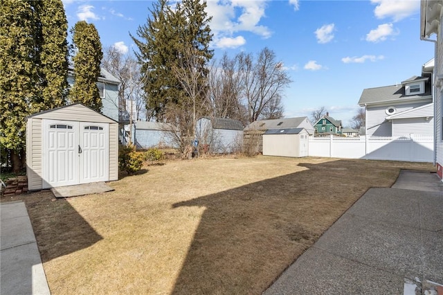 view of yard featuring a storage shed, fence, and an outdoor structure