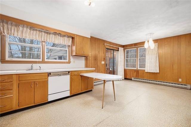 kitchen with light floors, dishwasher, wood walls, light countertops, and a baseboard radiator