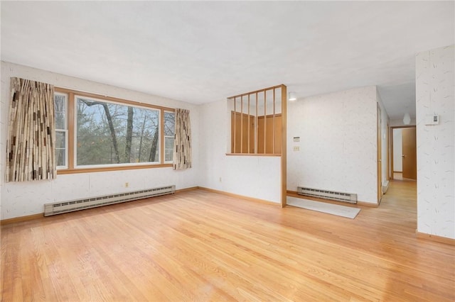 spare room with a baseboard heating unit, wood finished floors, baseboards, and baseboard heating