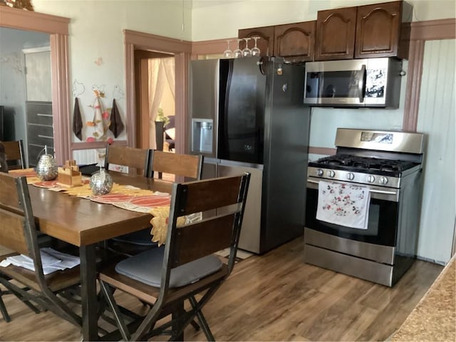 kitchen featuring stainless steel appliances, light wood-style floors, and dark brown cabinetry