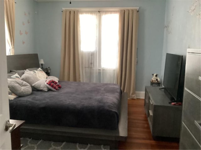 bedroom featuring multiple windows and wood finished floors