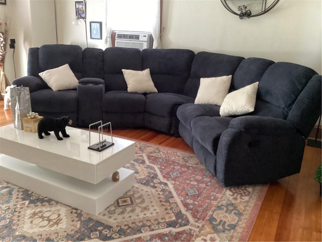 living area featuring cooling unit and wood finished floors