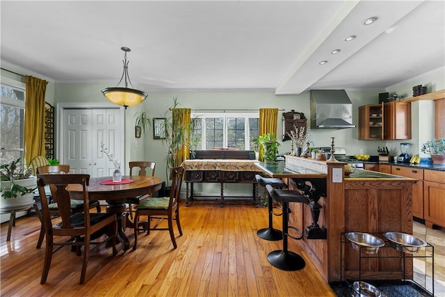 dining space featuring light wood finished floors, recessed lighting, and crown molding