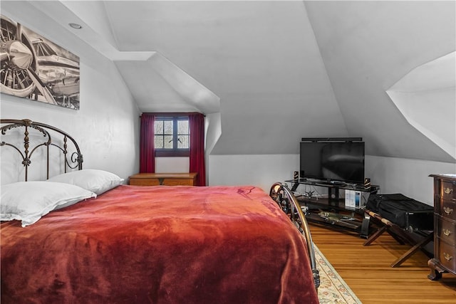 bedroom with lofted ceiling and wood finished floors