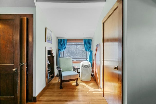 hall featuring light wood-style flooring and baseboards