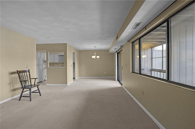 interior space with a notable chandelier, visible vents, light colored carpet, and baseboards