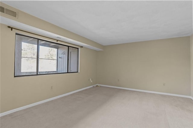 unfurnished room featuring light carpet, visible vents, and baseboards