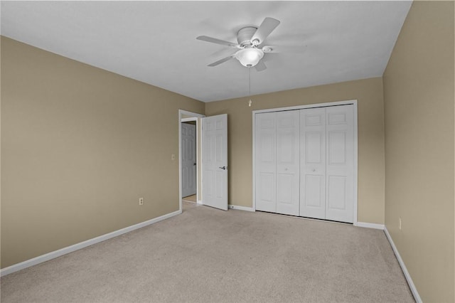 unfurnished bedroom featuring a closet, light colored carpet, a ceiling fan, and baseboards