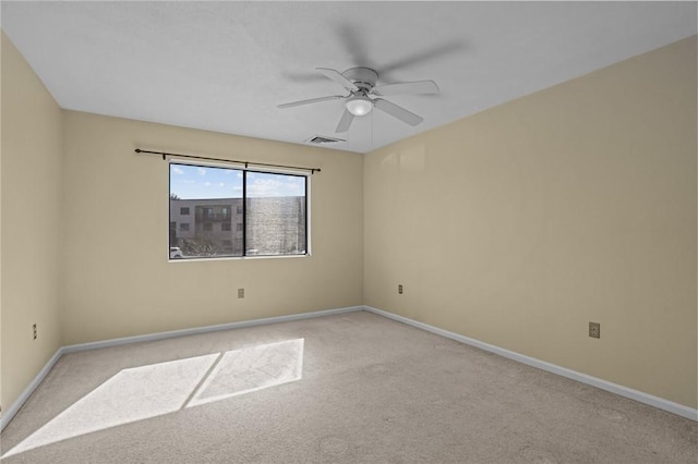 spare room with visible vents, light carpet, baseboards, and a ceiling fan