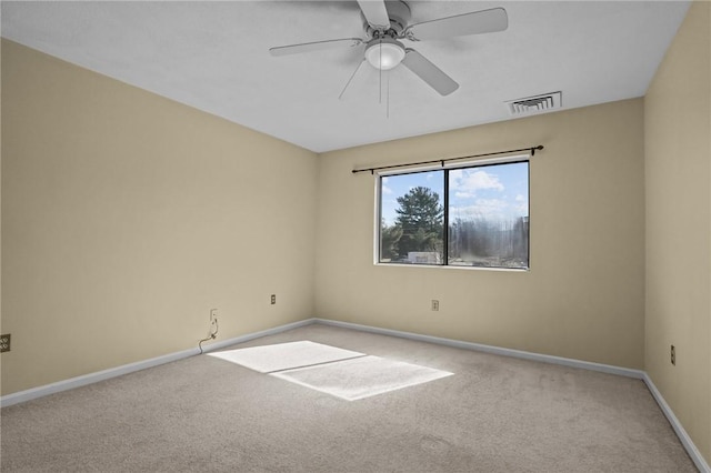 carpeted empty room with visible vents, a ceiling fan, and baseboards