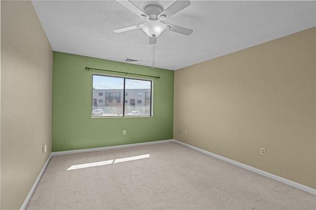 spare room with visible vents, baseboards, carpet, and a ceiling fan