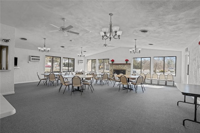 unfurnished dining area featuring visible vents, a fireplace, vaulted ceiling, carpet flooring, and ceiling fan with notable chandelier