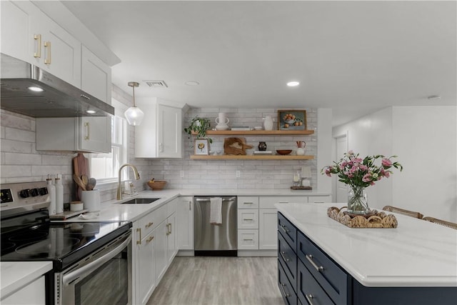 kitchen with a sink, under cabinet range hood, white cabinetry, stainless steel appliances, and light countertops