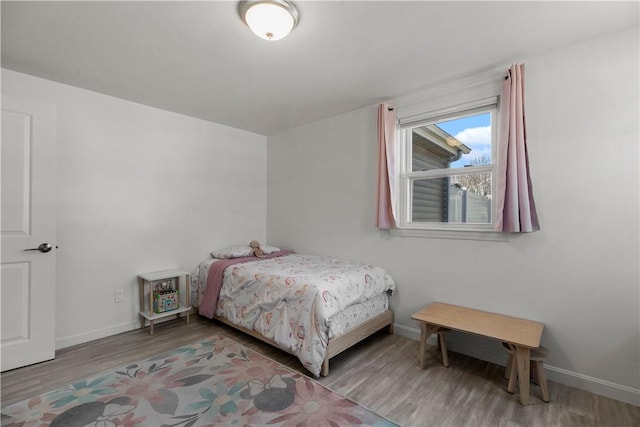 bedroom with baseboards and wood finished floors