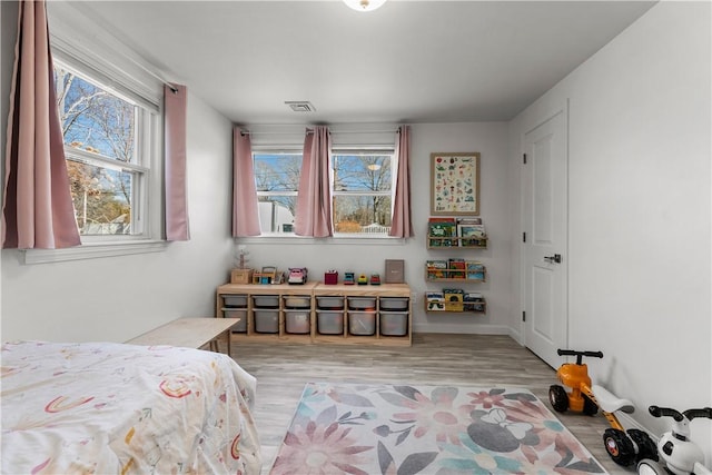 bedroom with visible vents and light wood-style flooring