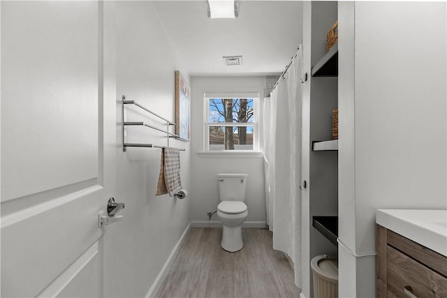 bathroom with visible vents, toilet, wood finished floors, baseboards, and vanity