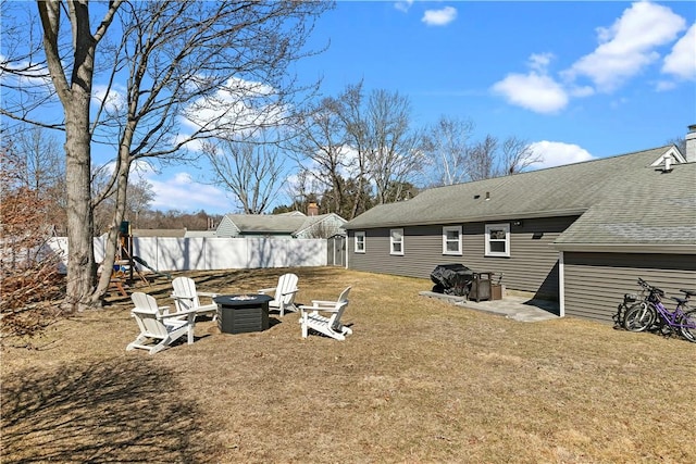 view of yard featuring an outdoor fire pit and fence