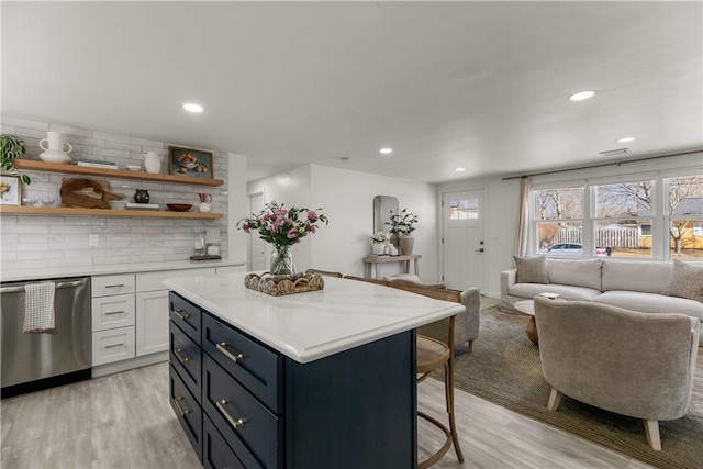 kitchen with open floor plan, dishwasher, a kitchen bar, white cabinetry, and open shelves