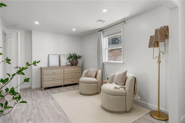 living area with recessed lighting, visible vents, baseboards, and light wood-style flooring