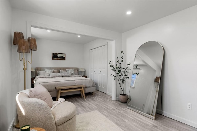 bedroom featuring recessed lighting, light wood-style floors, baseboards, and a closet