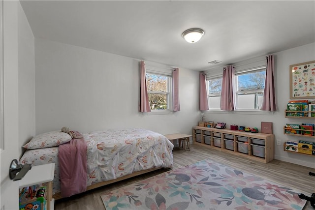 bedroom with wood finished floors and visible vents