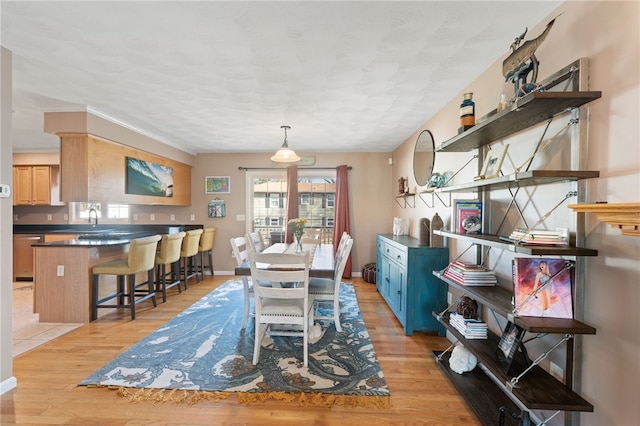 dining area featuring baseboards and light wood-style floors