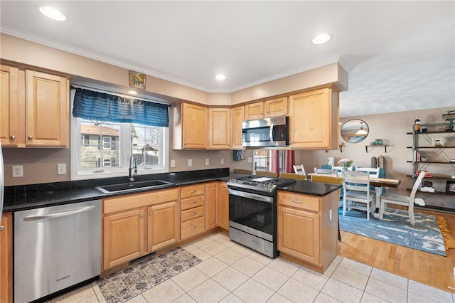 kitchen featuring light brown cabinets, a sink, dark countertops, stainless steel appliances, and light tile patterned floors