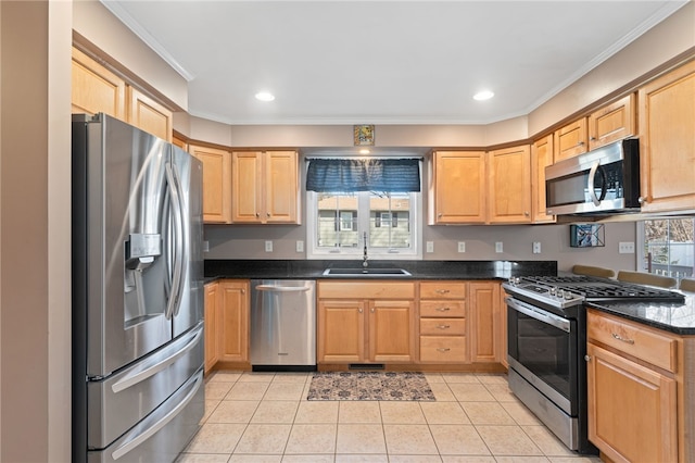 kitchen with a sink, dark countertops, stainless steel appliances, light tile patterned flooring, and crown molding