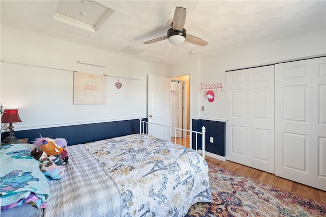 bedroom featuring a ceiling fan, attic access, wood finished floors, and a closet