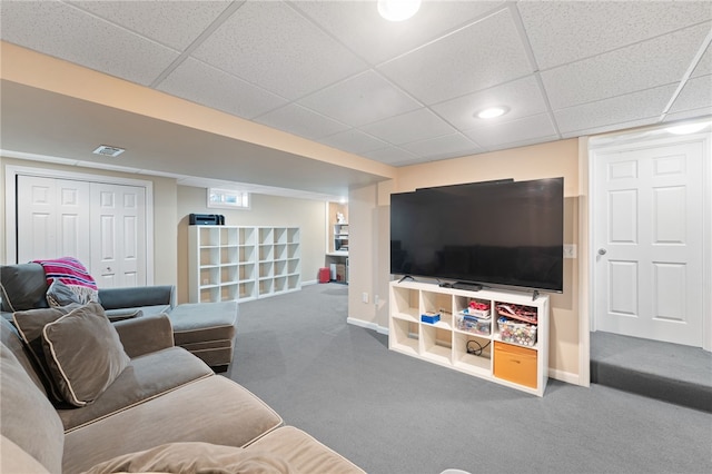 living room with a paneled ceiling, visible vents, baseboards, and carpet flooring