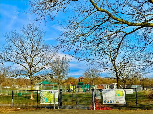 view of community featuring a yard, playground community, and fence