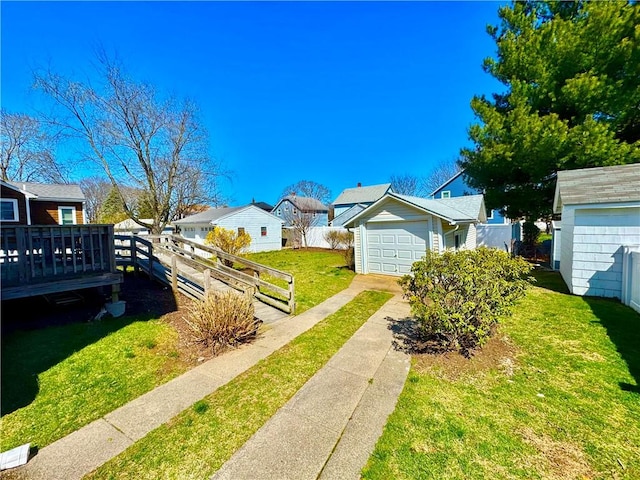 exterior space featuring fence, driveway, a residential view, and a wooden deck
