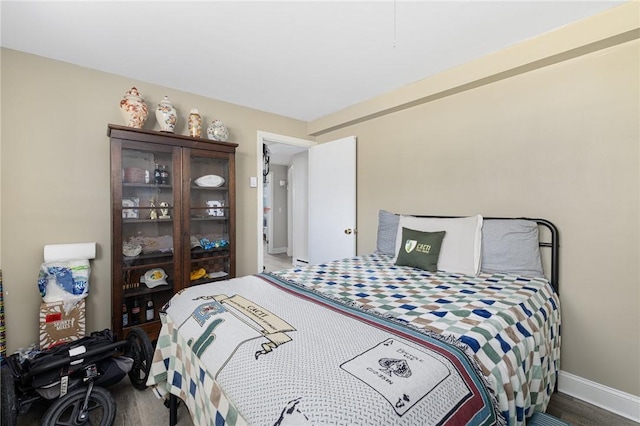 bedroom with baseboards and wood finished floors