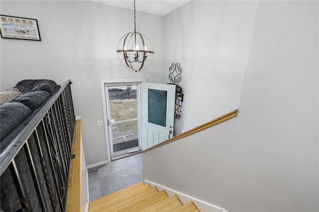 stairs featuring baseboards and an inviting chandelier