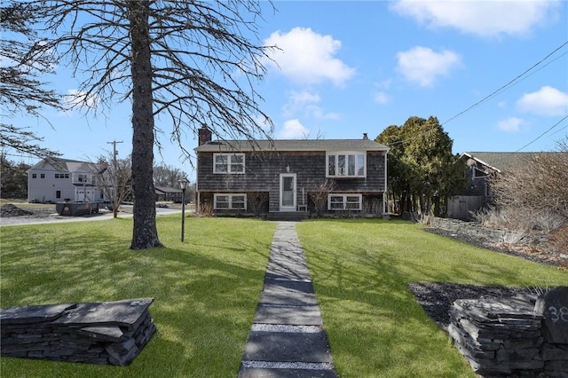 raised ranch with a chimney and a front yard