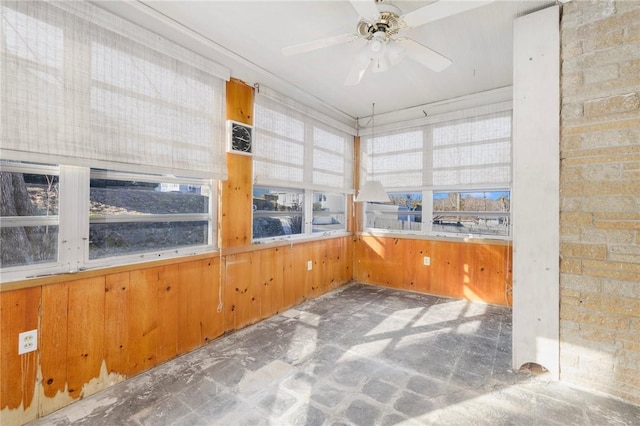 unfurnished sunroom with ceiling fan