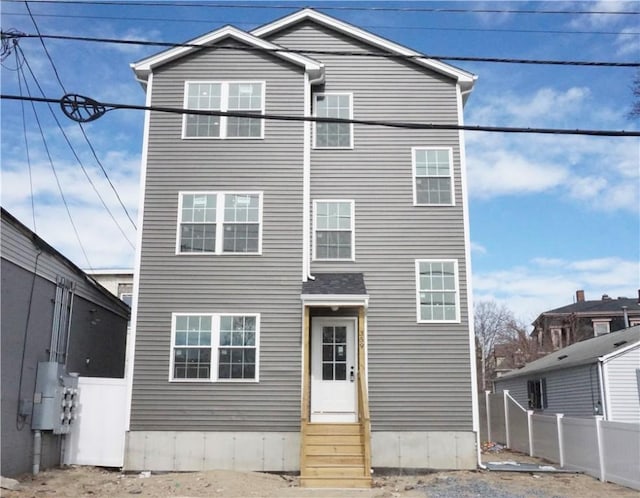 rear view of house featuring fence and entry steps