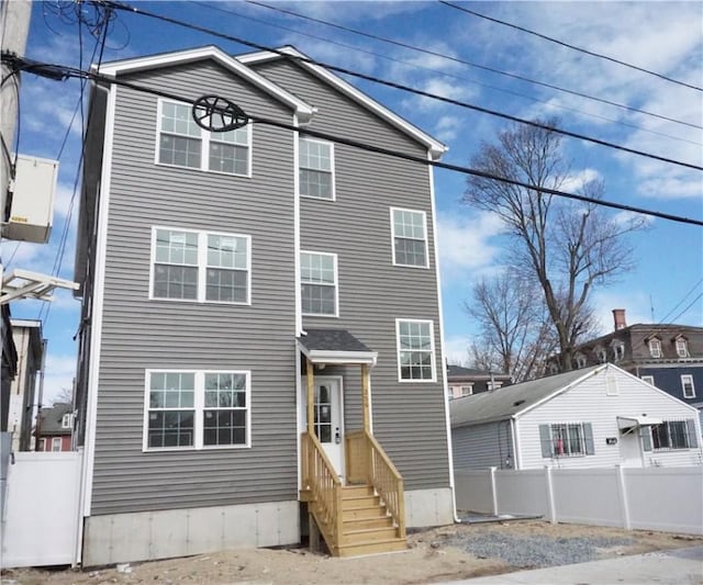 view of front of home with entry steps and fence