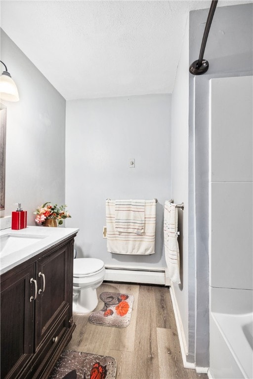 full bath featuring a baseboard heating unit, walk in shower, wood finished floors, and vanity