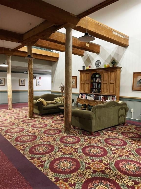 living room with beam ceiling and decorative columns