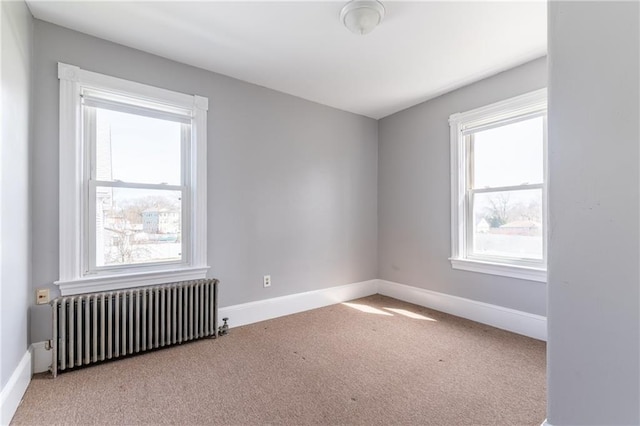 unfurnished room with radiator, carpet, and baseboards