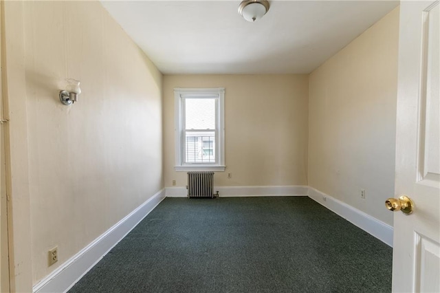 empty room with dark colored carpet, baseboards, and radiator heating unit