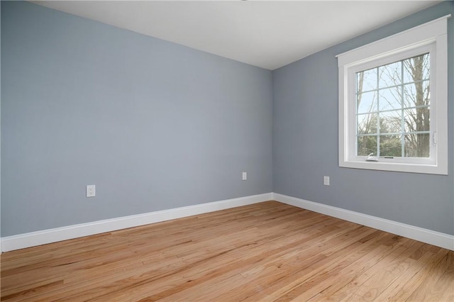 spare room with light wood-style flooring and baseboards