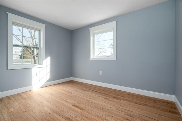 empty room with baseboards and light wood-type flooring