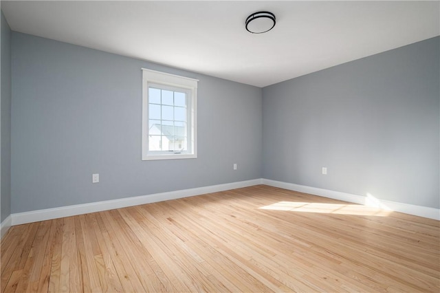 empty room with baseboards and light wood-style floors