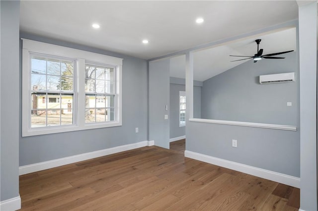 spare room featuring recessed lighting, a wall mounted air conditioner, baseboards, and wood finished floors