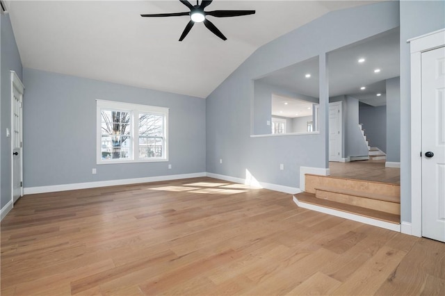 unfurnished living room featuring baseboards, ceiling fan, stairs, vaulted ceiling, and light wood-type flooring