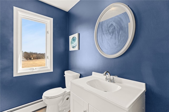 half bathroom with baseboard heating, vanity, and toilet